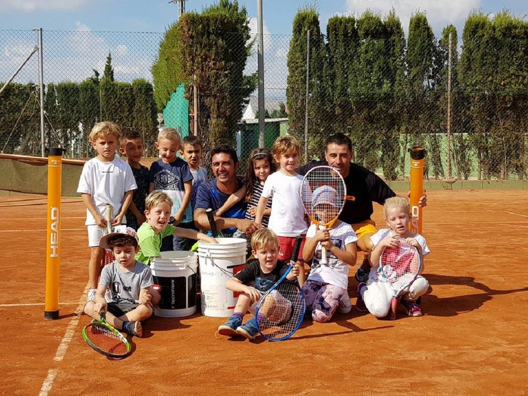 niños y niñas junto a sus entrenadores a pie de pista